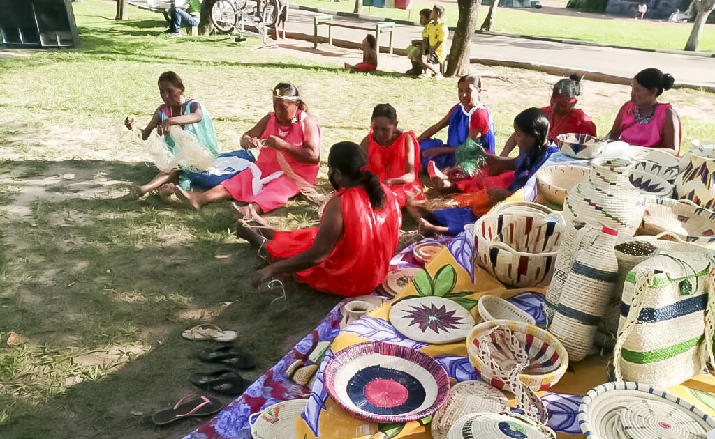 Mulheres migrantes indígenas warao confeccionam artesanatos para vender em Boa Vista.